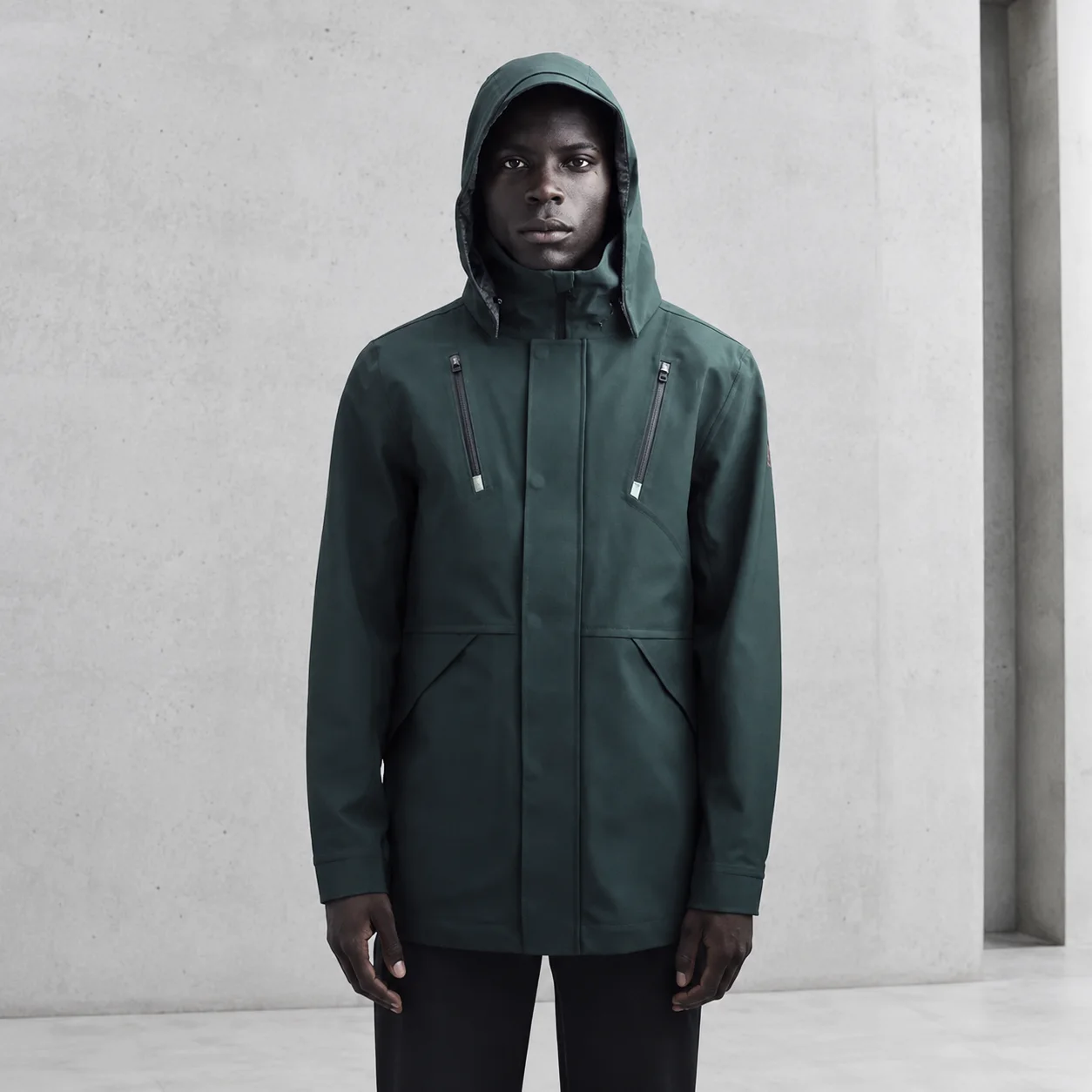 Front view of the Ulterior Waterproof Hardshell Jacket against a concrete background